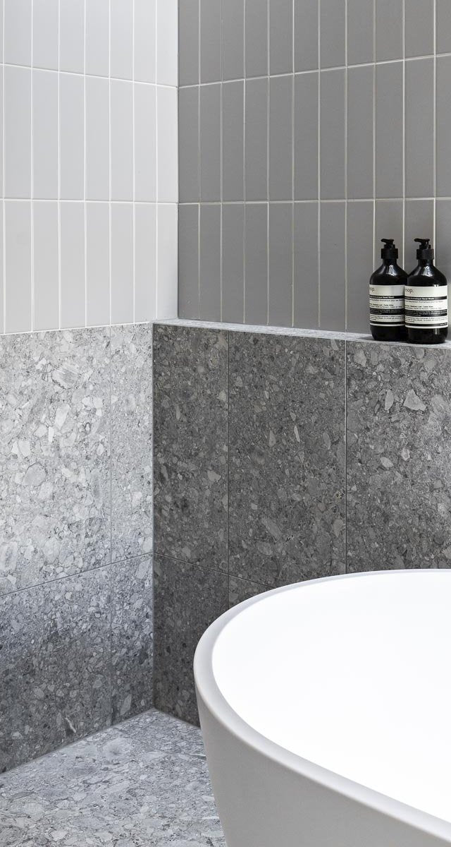 Modern gray designed bathroom with patterned tiles and a bathtub