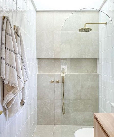Bathroom with modern mixed tiles and golden shower